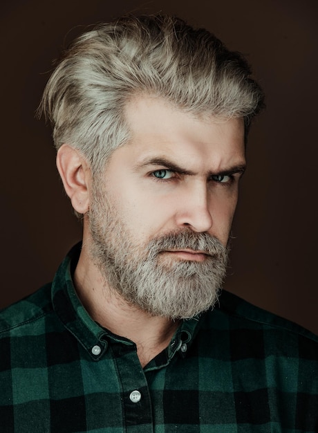 Beautiful guy in shirt looking to the camera isolated over grey background portrait of handsome man