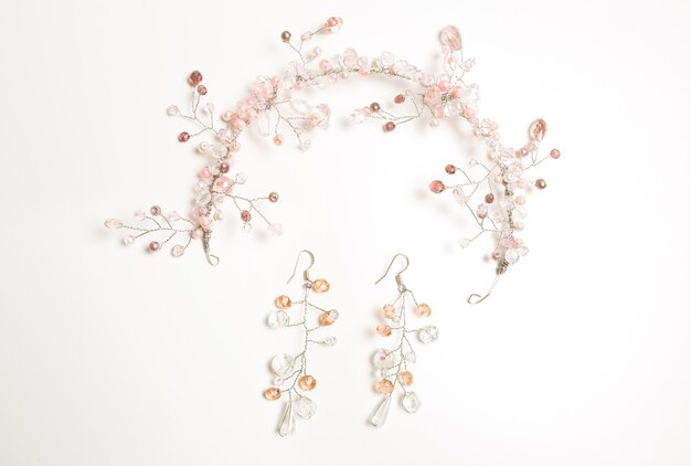 Photo beautiful hair accessory and earrings decorated with white and pink beads over a white background