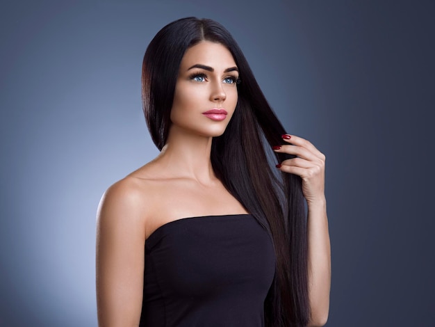 Beautiful hair woman with long brunette hairstyle. Studio shot.