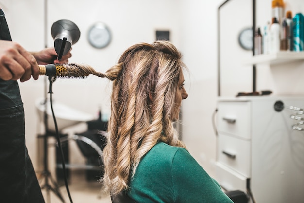 Photo beautiful hairstyle of mature woman after dying hair and making highlights in hair salon.