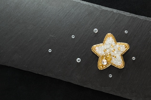 Beautiful handmade embroidered brooch,white and golden star with crystals, flat top view dark stone