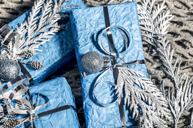 写真 シルバーブルーの美しい手作りの新年プレゼント。銀と青の背景を持つクリスマスカード。松、モミの木、ギフトボックスのクリスマスデコレーション。閉じる、