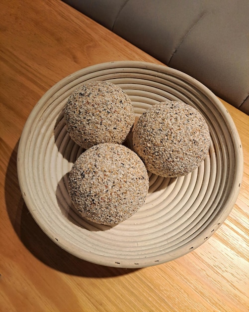 Beautiful handmade round vase made of clay with balls inside on a wooden table