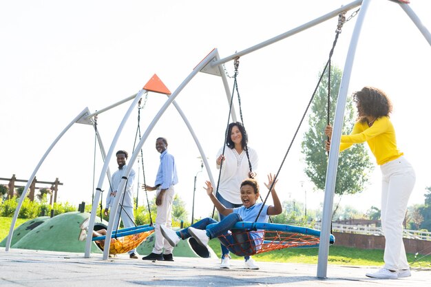 Beautiful happy african american family bonding at the park - Black family having fun outdoors