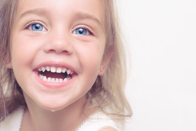 Foto faccia bella, felice bambina con grandi occhi blu in bagno