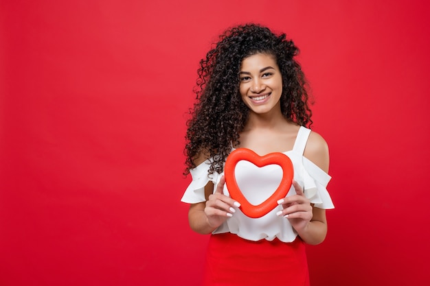 Beautiful  happy black woman with heart shape in hands