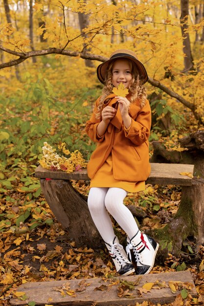 Фото Красивая счастливая блондинка в бежевом пальто в шляпе в городском парке осенью