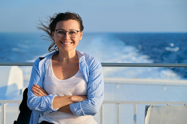 Beautiful happy confident mature woman on deck of ship ferry enjoying sea voyage