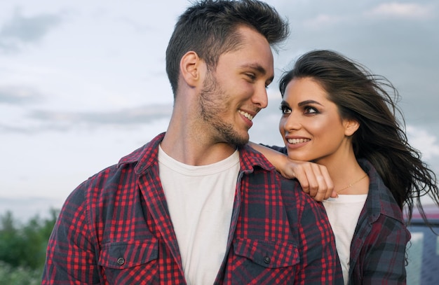 Beautiful happy couple have dating in the park showing a happy relationship goals Handsome Caucasian man wearing casual shirt with smiling girlfriend hugs him Lifestyle people and travel concept