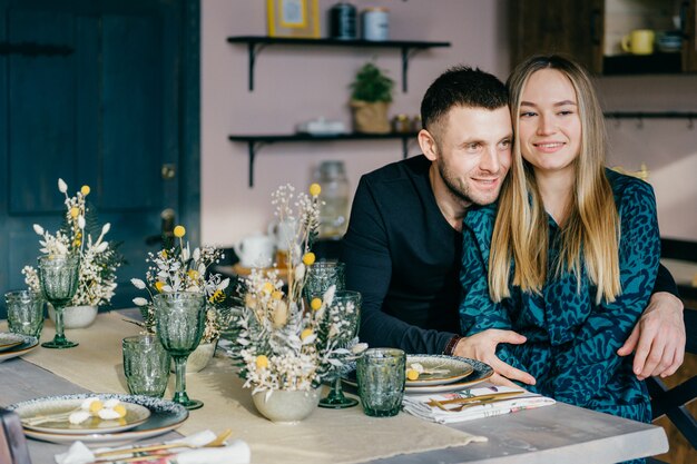 Beautiful happy couple in love are hugging at decorated table