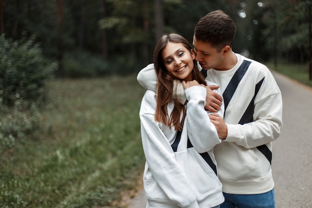 Beautiful happy couple in love in stylish white clothes in nature