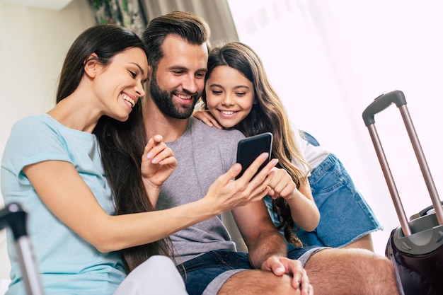 Beautiful happy excited family with a backpack and suitcases in modern hotel