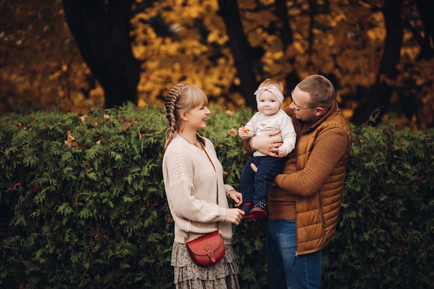 Beautiful and happy family with little child in park