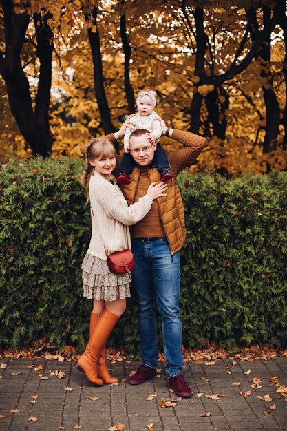 Beautiful and happy family with little child in park