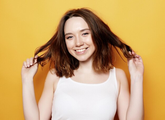 Beautiful happy girl touches her hair