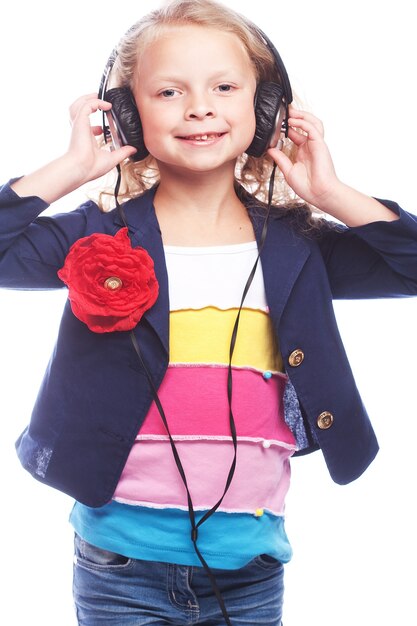 Beautiful happy little girl with headphones. Isolated on white.