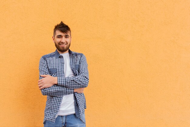 The beautiful and happy man against the orange wall