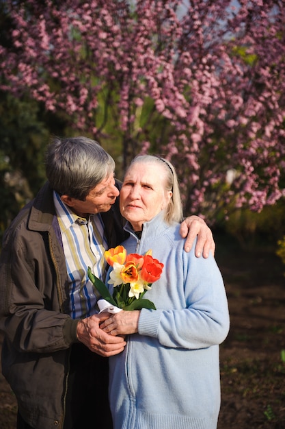 Beautiful happy old people sitting in the autumn park