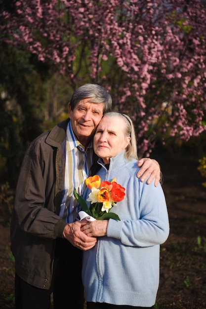 Beautiful happy old people sitting in the autumn park.