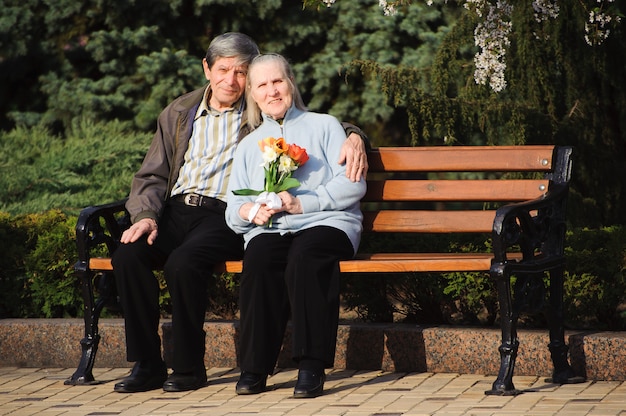 Beautiful happy old people sitting in the spring park