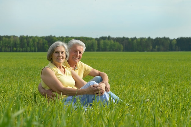 Beautiful happy senior couple have fun in summer field