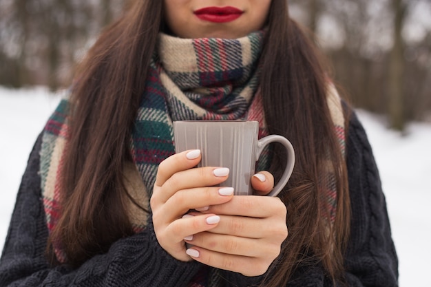 路上で冬のカップと美しい幸せな笑顔の女性