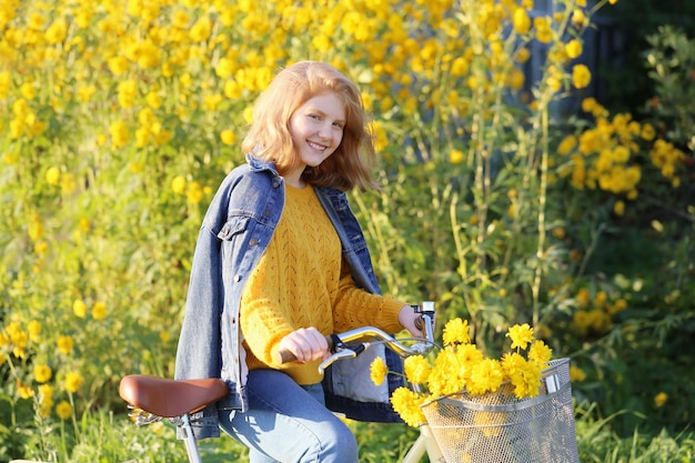 Beautiful happy teen girl on bike in sunny garden