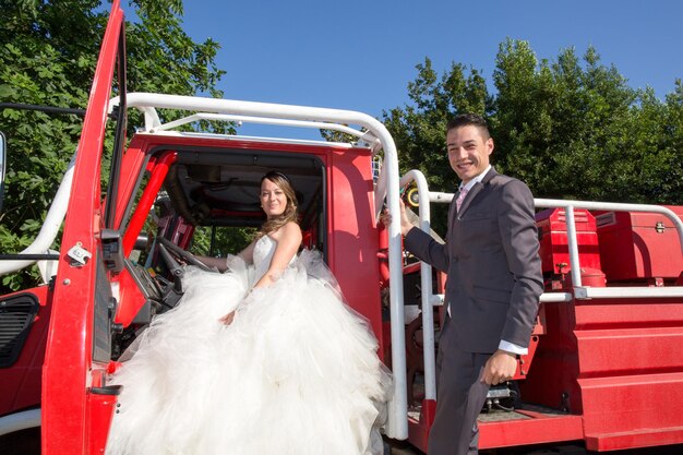 Beautiful and happy wedding couple on fire truck