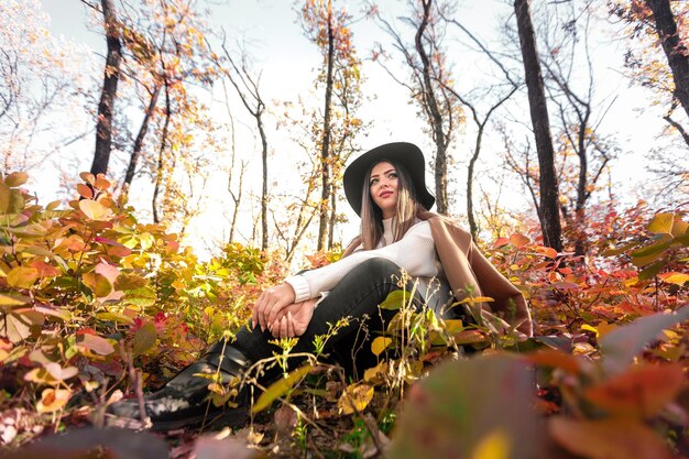 Beautiful happy woman in coat and hat in forest