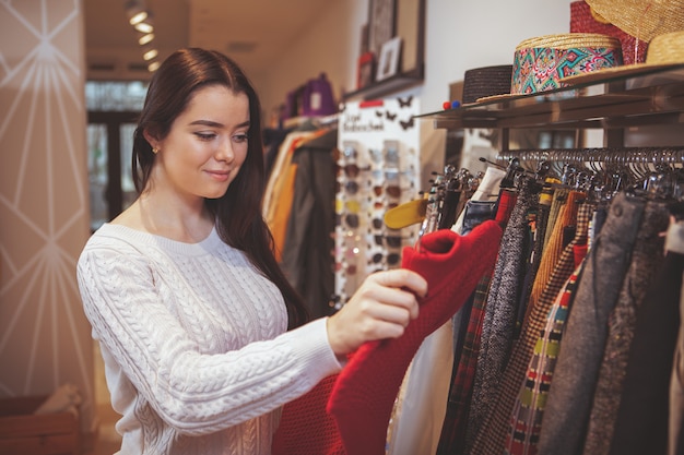 Beautiful happy woman enjoying shopping at clothing store