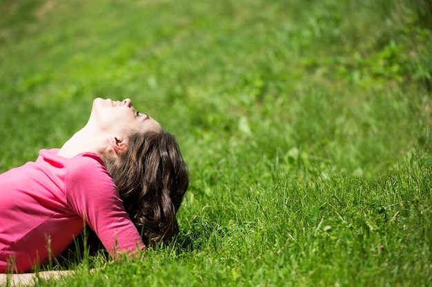 Beautiful happy woman on green grass Relaxation outdoors