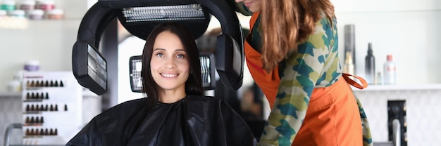 Beautiful happy woman sits in chair and dries hair