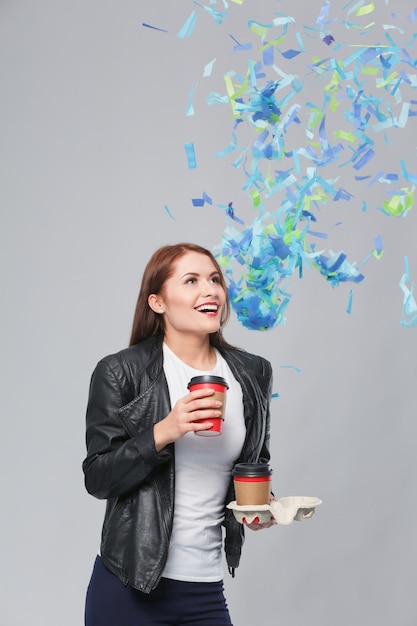 Beautiful happy woman with coffee at celebration party with confetti Birthday or New Year eve celebrating concept