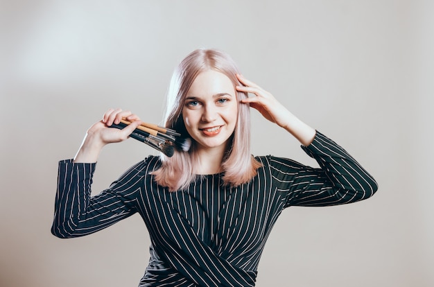 Photo beautiful happy woman with makeup brushes near her face