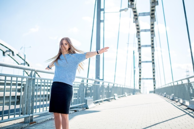 Beautiful happy young businesswoman using cell phone on city street