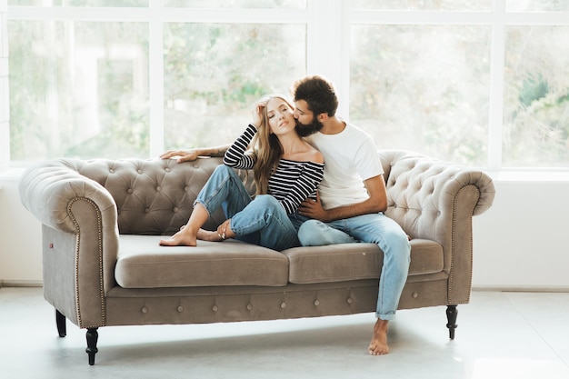 Beautiful and happy young couple in love or family in casual wear having fun