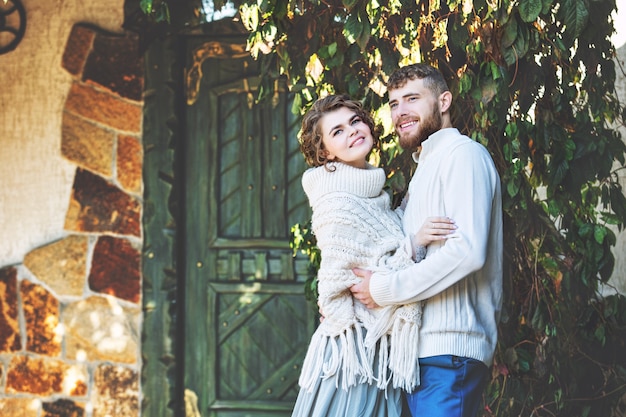 Beautiful and happy young couple man and woman in a beautiful garden in the yard of a country house