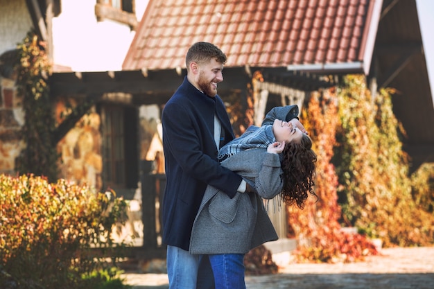 Beautiful and happy young couple man and woman in a beautiful garden in the yard of a country house