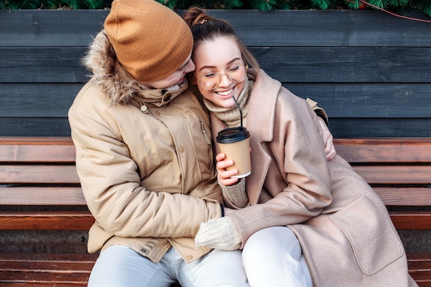 Beautiful happy young funny couple have fun together outdoor on the street in cold winter