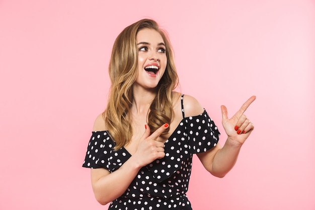 a beautiful happy young pretty woman posing isolated over pink wall showing copyspace