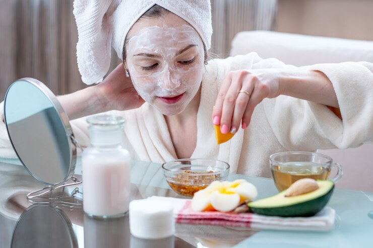 Beautiful happy young woman with natural cosmetic mask on her face. Skin care and Spa treatments at home