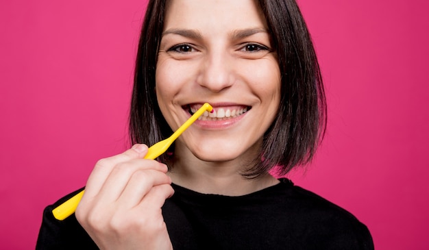 Красивая счастливая молодая женщина с одной хохлатой зубной щеткой