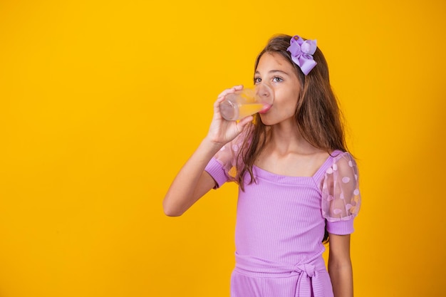 Beautiful healthy little girl drinking a glass of water.