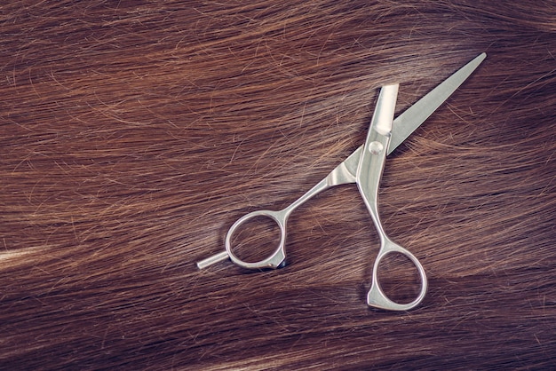 Photo beautiful healthy shiny hair and professional scissors.