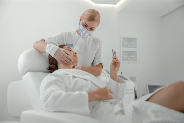 Photo beautiful healthy smiling caucasian woman is doing beauty procedures at spa and healthcare salon