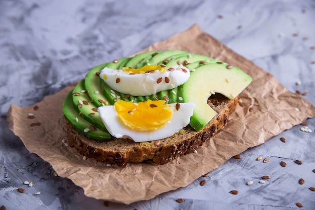 美しい健康的なスナック - 卵とアボカドのサンドイッチ。ベジタリアン料理のコンセプト