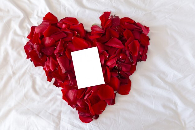 Beautiful heart of red rose petals with blank greeting card for valentine