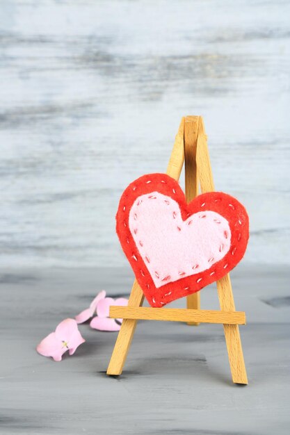 Beautiful heart  small decorative easel on grey background