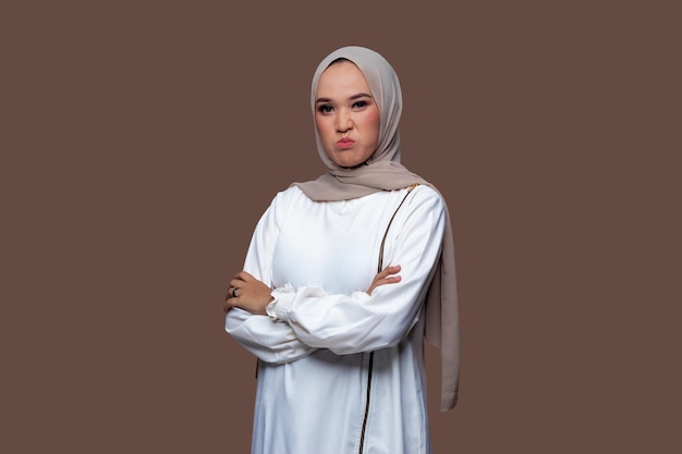 Beautiful hijab woman looking ahead with a fierce angry expression isolated on plain background