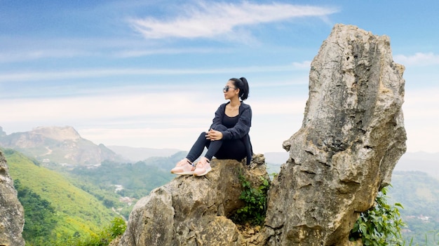 Beautiful hiker sitting on rock